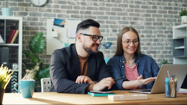 a man and a woman sitting at a laptop